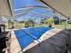 Screened-in pool with cover, offering a relaxing outdoor space, and lush greenery at 22589 Nyack Ave, Port Charlotte, FL 33952