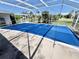 Covered pool area featuring a bright blue pool cover with a view of the surrounding landscape at 22589 Nyack Ave, Port Charlotte, FL 33952