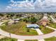 Aerial view of property showcasing the home's location, large lot, and proximity to a pond at 23 Bunker Cir, Rotonda West, FL 33947
