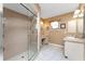Bright ensuite bathroom with vanity, storage, walk-in glass shower, and tile floors at 23 Bunker Cir, Rotonda West, FL 33947