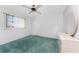 Bedroom featuring green carpeting, a ceiling fan, and a dresser with an oval mirror at 23 Bunker Cir, Rotonda West, FL 33947