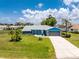 Inviting home featuring a lush lawn, mature landscaping, and a driveway leading to a two-car garage at 23 Bunker Cir, Rotonda West, FL 33947