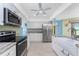 Modern kitchen with stainless steel appliances, white cabinetry, and a farmhouse sink at 23 Bunker Cir, Rotonda West, FL 33947