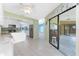 Open concept kitchen with white cabinetry, granite countertops, stainless appliances, tile floors, and backyard access at 23 Bunker Cir, Rotonda West, FL 33947