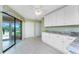 Bright kitchen with white cabinetry, granite countertops, backyard access, and tile floors at 23 Bunker Cir, Rotonda West, FL 33947