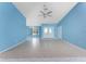 Large living room featuring tile flooring, blue walls, ceiling fan, and a double-door entry at 23 Bunker Cir, Rotonda West, FL 33947