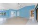Spacious living room with tile flooring, blue walls, ceiling fan, and double door entry at 23 Bunker Cir, Rotonda West, FL 33947
