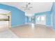 Expansive living room with tile floors, blue walls, ceiling fan, and an open layout to the kitchen at 23 Bunker Cir, Rotonda West, FL 33947