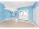 Bright and airy living room with tile flooring, blue walls, and a double-door entry at 23 Bunker Cir, Rotonda West, FL 33947