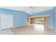 Open living room featuring tile floors, blue walls, and a seamless transition to an enclosed lanai at 23 Bunker Cir, Rotonda West, FL 33947