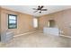 Spacious main bedroom with carpet, two windows, ceiling fan, and ensuite bathroom at 23 Bunker Cir, Rotonda West, FL 33947