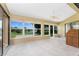 Bright sunroom with tile floor, ceiling fan, and sliding glass doors with expansive views at 23 Bunker Cir, Rotonda West, FL 33947