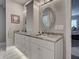 Bright bathroom featuring dual sinks, white cabinetry, granite countertops, and oval mirrors at 2590 Tarpon Cove Dr # 811, Punta Gorda, FL 33950