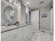 Bathroom featuring a white vanity with marble countertops, elegant light fixtures, and oval mirrors at 2590 Tarpon Cove Dr # 811, Punta Gorda, FL 33950