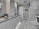 Bright bathroom featuring dual sinks, white cabinetry, granite countertops, and marble-tiled floors at 2590 Tarpon Cove Dr # 811, Punta Gorda, FL 33950