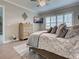 Bedroom with a dresser, TV, plantation shutters, and a bed with decorative pillows and grey bedding at 2590 Tarpon Cove Dr # 811, Punta Gorda, FL 33950