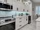 Bright kitchen with white cabinets, stainless steel appliances, granite countertops, and tile flooring at 2590 Tarpon Cove Dr # 811, Punta Gorda, FL 33950