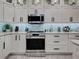 Stylish kitchen featuring stainless steel appliances, white cabinets, granite countertops, and contemporary design at 2590 Tarpon Cove Dr # 811, Punta Gorda, FL 33950