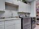 Well-equipped laundry room featuring gray machines, white cabinets, granite countertop, and a convenient sink at 2590 Tarpon Cove Dr # 811, Punta Gorda, FL 33950