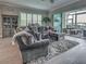 Open living room area with a plush sectional sofa, built-in shelving, and a bright sunroom at 2590 Tarpon Cove Dr # 811, Punta Gorda, FL 33950