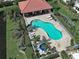 Aerial view of a Kidney bean-shaped pool and whirlpool with an adjacent shaded structure and white lounge chairs at 2590 Tarpon Cove Dr # 811, Punta Gorda, FL 33950