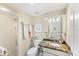Bathroom with a marble counter, decorative mirror, and glass-enclosed shower, offering style and functionality at 2700 N Beach Rd # B205, Englewood, FL 34223