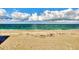 Sandy beach, clear aqua-green water, blue sky, and fluffy clouds for your enjoyment at 2700 N Beach Rd # B205, Englewood, FL 34223