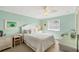 Bright bedroom with white furniture, ceiling fan, and coastal decor with a window for natural light at 2700 N Beach Rd # B205, Englewood, FL 34223