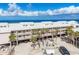 Oceanfront condo building with multiple levels and parking, surrounded by palm trees at 2700 N Beach Rd # B205, Englewood, FL 34223