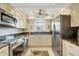 Well-lit kitchen with stainless steel appliances, granite countertops, and a palm frond ceiling fan at 2700 N Beach Rd # B205, Englewood, FL 34223