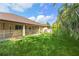 Spacious backyard featuring a screened-in patio, lush green grass, and mature landscaping at 2758 Morrietta Ln, North Port, FL 34286