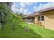 Lush backyard featuring a well-maintained lawn and tropical landscaping for privacy and beauty at 2758 Morrietta Ln, North Port, FL 34286