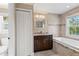 Well-lit bathroom with a soaking tub, granite countertop, and classic white door at 2758 Morrietta Ln, North Port, FL 34286