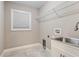 Bright laundry room with sink, modern faucet, white cabinets, and window for natural light at 2758 Morrietta Ln, North Port, FL 34286