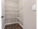 Spacious pantry featuring wire shelving and dark wood-look flooring for optimal organization at 2758 Morrietta Ln, North Port, FL 34286