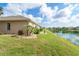 Beautiful backyard with manicured lawn and landscaping that leads to a serene pond at 278 Crystal River Dr, Englewood, FL 34223