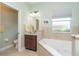 Well-lit bathroom with large soaking tub, vanity, and decorative mirror at 278 Crystal River Dr, Englewood, FL 34223