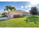Charming exterior of home with well-maintained lawn, palm trees, and an attached two-car garage at 278 Crystal River Dr, Englewood, FL 34223