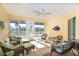 Bright sunroom with comfortable seating, ceiling fan, and serene water views at 278 Crystal River Dr, Englewood, FL 34223