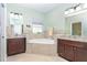Main bathroom features dual vanities, corner tub, and neutral tile work at 278 Crystal River Dr, Englewood, FL 34223