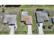 An aerial view showcases three houses with different roof colors and shapes, each with its own unique backyard space and landscaping at 279 Mark Twain Ln, Rotonda West, FL 33947