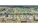 Aerial view of a residential community with houses, lawns, a golf course, and waterfront canal at 279 Mark Twain Ln, Rotonda West, FL 33947