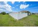 Green backyard with pristine white fence, offering a serene and private outdoor space for relaxation and recreation at 279 Mark Twain Ln, Rotonda West, FL 33947