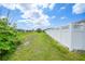 Lush green backyard featuring a well-maintained lawn and a crisp white fence, perfect for outdoor enjoyment and privacy at 279 Mark Twain Ln, Rotonda West, FL 33947
