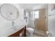 Clean bathroom with a unique glass sink, wooden cabinet, round mirror, and glass door shower at 279 Mark Twain Ln, Rotonda West, FL 33947