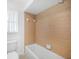 Cozy bathroom with a tiled shower and tub, featuring a window to let in natural light, and a white toilet at 279 Mark Twain Ln, Rotonda West, FL 33947