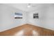 Comfortable bedroom with hardwood floors, two windows with blinds, and a ceiling fan for added comfort at 279 Mark Twain Ln, Rotonda West, FL 33947