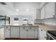 Bright kitchen featuring granite countertops, stainless sink and white cabinetry at 279 Mark Twain Ln, Rotonda West, FL 33947