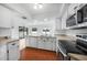 Modern kitchen with white cabinetry, wood floors, and stainless steel appliances at 279 Mark Twain Ln, Rotonda West, FL 33947
