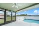 A screened-in patio features a ceiling fan and view of a tranquil pool area and lush green backyard at 279 Mark Twain Ln, Rotonda West, FL 33947